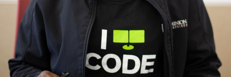 Female computer science student wearing a shirt that says 'I Code.'